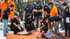 ジャカルタの港で救助隊員が回収した物品や破片を調査＝１０日