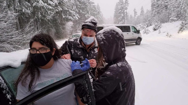 雪で立ち往生中の運転手らに、たまたま手元に残っていたワクチンを接種する医療関係者/Josephine County Public Health
