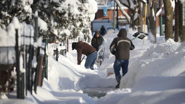 道路の雪かきをする人たち＝１６日、イリノイ州シカゴ/Scott Olson/Getty Images