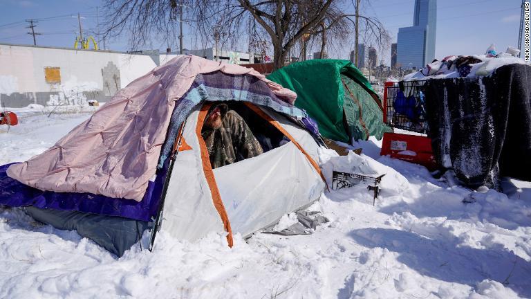 テントで雪の様子を確かめるホームレスの男性＝１５日、オクラホマ州オクラホマシティー/Nick Oxford/Reuters