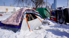 テントで雪の様子を確かめるホームレスの男性＝１５日、オクラホマ州オクラホマシティー