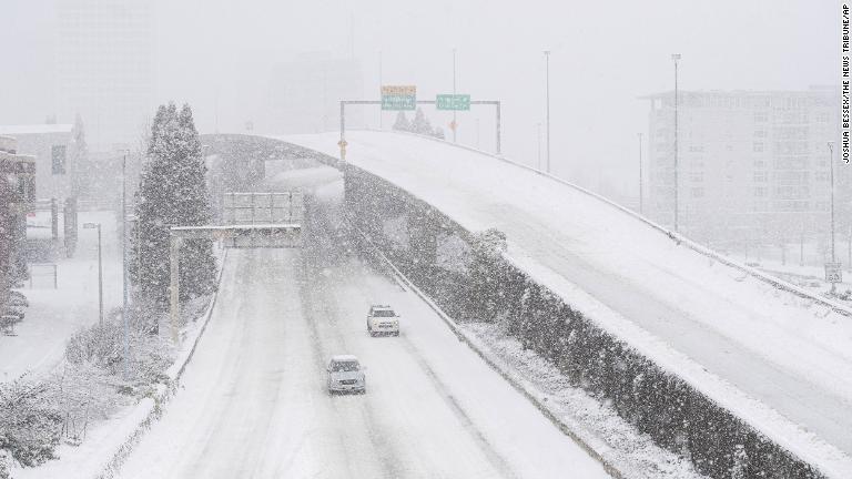 雪の降る幹線道路＝１３日、ワシントン州タコマ/Joshua Bessex/The News Tribune/AP