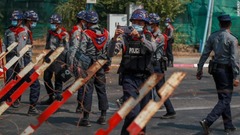 警察官がインドネシア大使館付近の抗議デモ参加者を撮影＝２月２４日、ヤンゴン