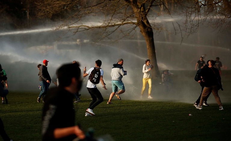 警察による放水を受けて逃げ惑う参加者ら/ Francisco Seco/AP