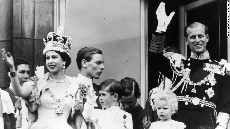女王エリザベス２世（左）の戴冠式にバッキンガム宮殿のバルコニーから手を振るフィリップ殿下＝１９５３年６月/Hulton Archive/Getty Images