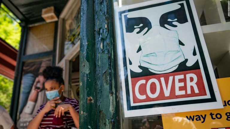 米ニューヨーク市マンハッタン区ソーホーの小売店からマスクをした客が出てくる＝１４日/John Minchillo/AP