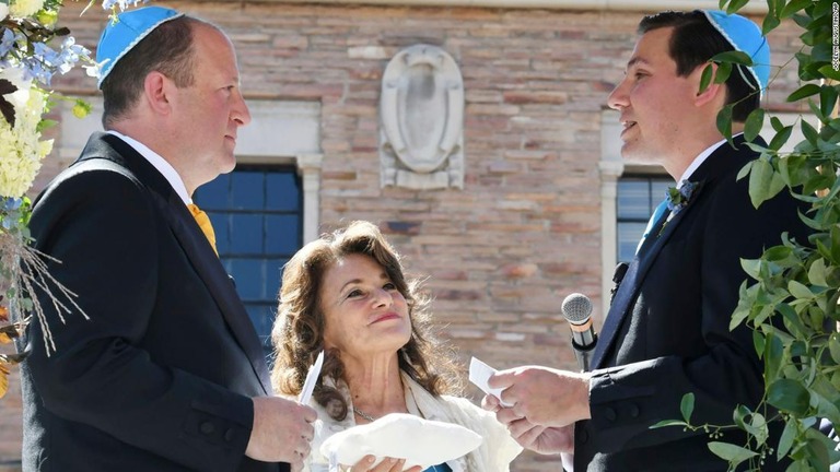 結婚した米コロラド州のジャレド・ポリス知事（左）と彼のパートナーのマーロン・リースさん（右）＝１５日/Jocelyn Augustino/AP