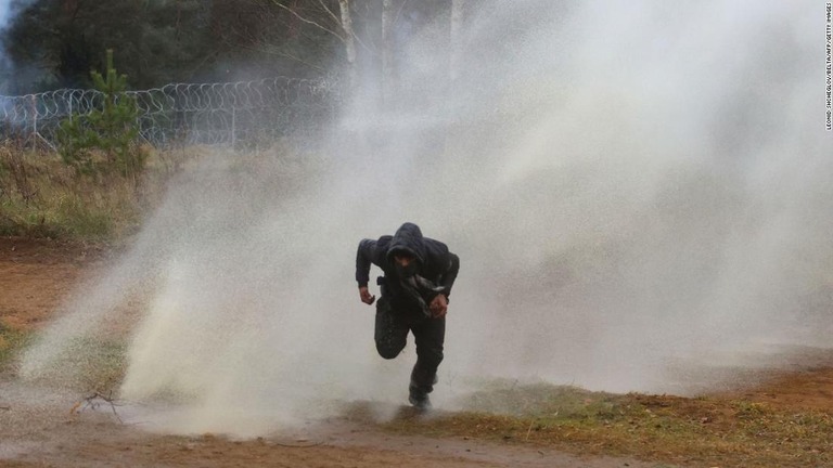 走って放水銃から逃げる男性/Leonid Shcheglov/Belta/AFP/Getty Images