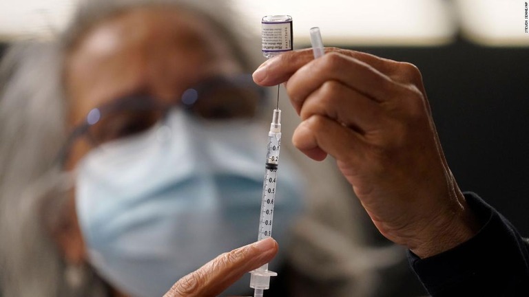 ファイザー製の新型コロナワクチンを準備する医師/Steven Senne/AP