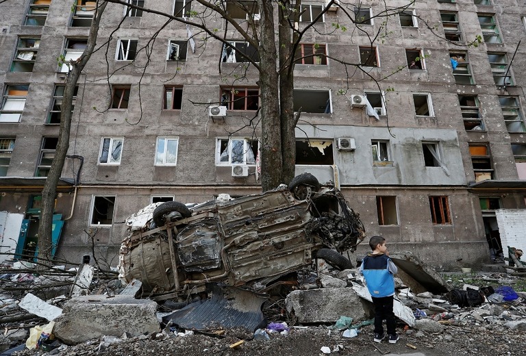 がれきのそばに立つ子ども＝２４日、ウクライナ・マリウポリ/Alexander Ermochenko/Reuters