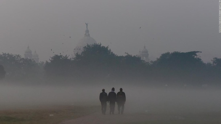 スモッグの中を歩く人々＝２０２１年１２月１５日、インド東部コルカタ/Indranil Aditya/NurPhoto/Getty Images