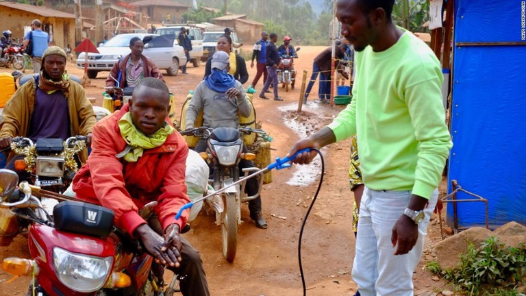 消毒液で手を洗うバイクタクシーの運転手＝コンゴ民主共和国（旧ザイール）東部の検問所/David McKenzie/CNN