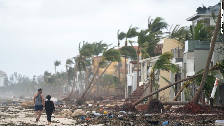 被害の状況を見ながら浜辺を歩く人々＝２９日、米フロリダ州ボニータ・スプリングス/Sean Rayford/Getty Images