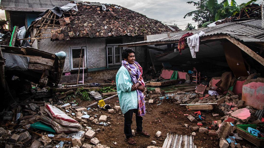 倒れた建物を見つめる住民＝２２日、チアンジュール/Aditya Aji/AFP/Getty Images