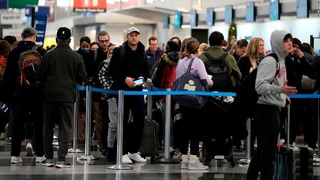 シカゴ・オヘア国際空港で保安検査に並ぶ人々＝２３日