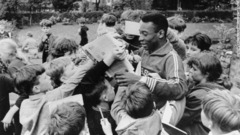 １９６６年、子どもたちにサインをするペレ。この年のＷ杯には出場したものの、ブラジルはグループステージを突破することができなかった