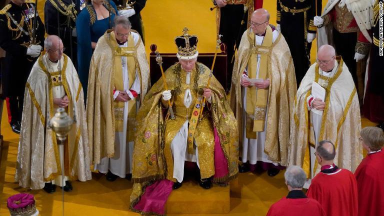 ５月６日、ウェストミンスター寺院での戴冠式で宝器を手に聖エドワード王冠を戴くチャールズ国王/Andrew Matthews/Pool/AP
