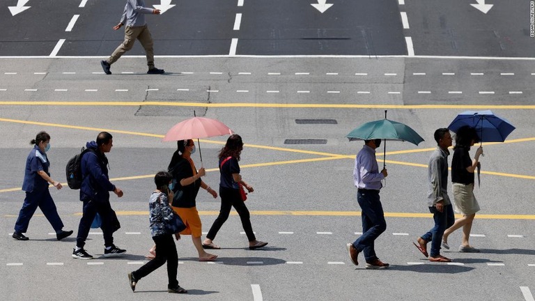 日傘をさして道路を歩く人々/Edgar Su/Reuters