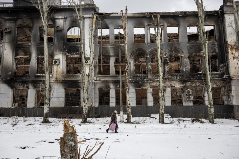 人道支援物資を手に戦闘で荒廃したバフムート中心部を歩く住民＝１４日、ウクライナ/John Moore/Getty Images