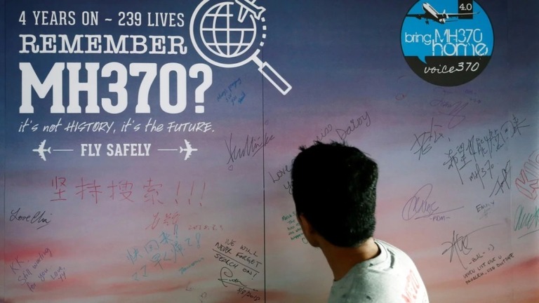 行方不明になった乗客へのメッセージに目を向ける男性＝２０１８年３月、マレーシア・クアラルンプール/Lai Seng Sin/Reuters/File