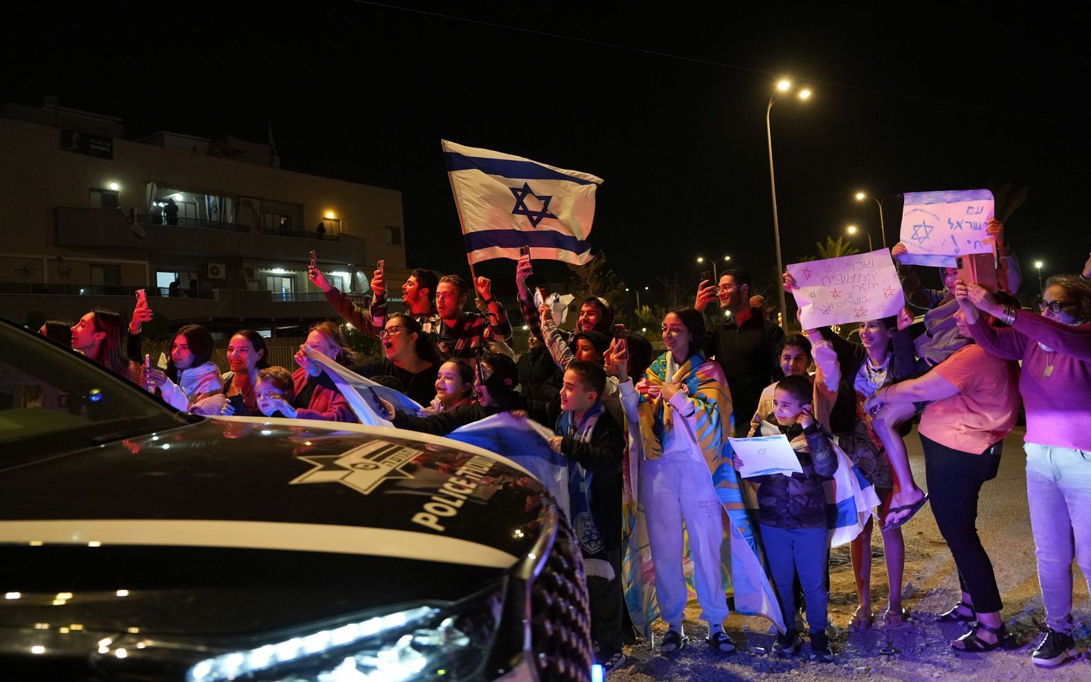 解放された人質を運んできた車両を歓迎する人々＝１１月２６日、イスラエル・オファキム/Tsafrir Abayov/AP