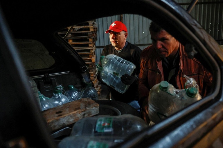 ウクライナ東部ドネツク州チャシフ・ヤルへの援助物資を車に積み込むボランティアの地元住民＝１１月８日、ウクライナ東部ドネツク州コスティニウカ/Alina Smutko/Reuters