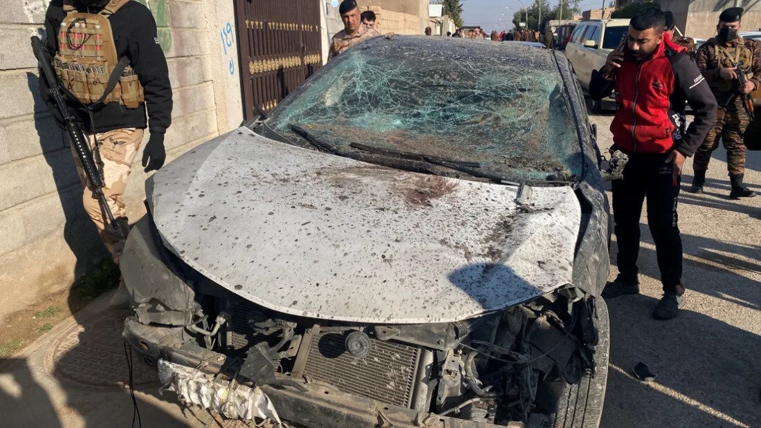損傷した車を調べる治安部隊＝３日、イラク・カイム/Stringer/Reuters