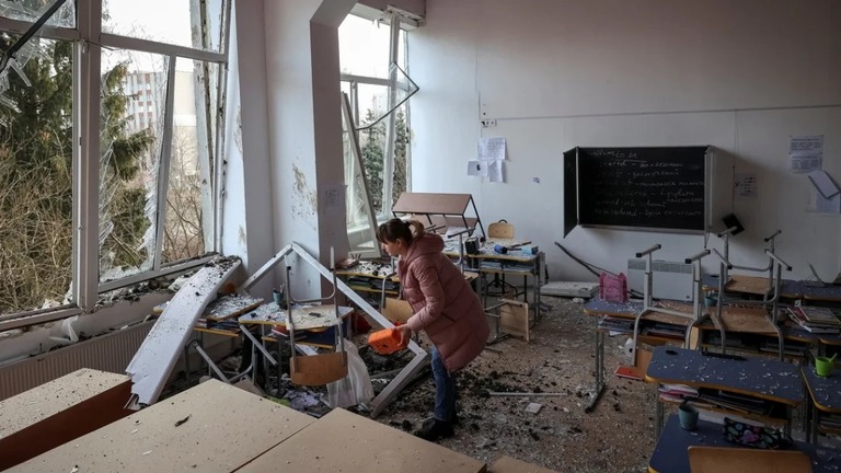 ロシア軍の攻撃後、ウクライナ西部リビウの学校で被害状況を確認する女性/Roman Baluk/Reuters