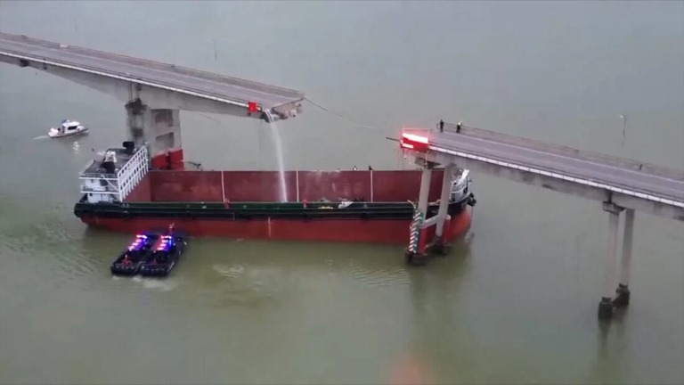 真っ二つに折れた橋の下に停止した貨物船/CCTV