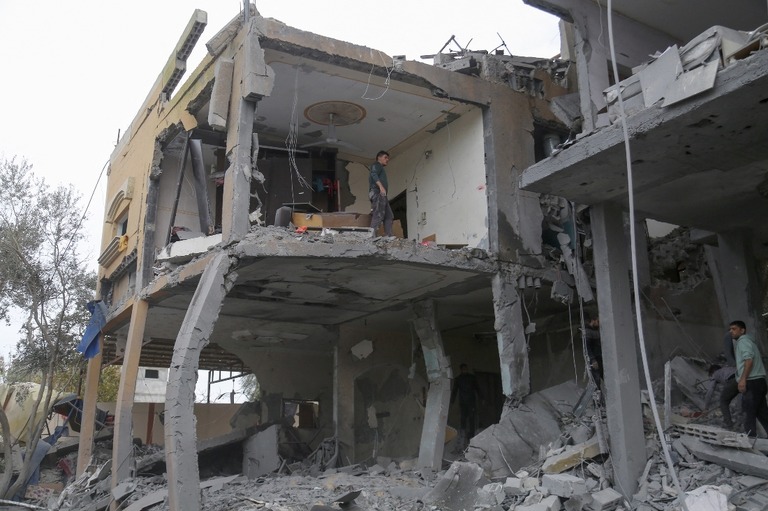 イスラエル軍による攻撃で破壊された住宅のがれきを捜索するパレスチナの人たち＝１６日、パレスチナ自治区ガザ地区中部/AFP/Getty Images