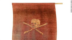 頭がい骨と十字型の骨をかたどったこの海賊船の旗は、ロンドンのカリー家に何世代にも渡って受け継がれている。１７００年代後半のものと思われ、火薬で焼けこげた跡が見られる