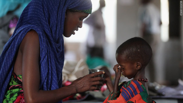 難民キャンプで食事を取る親子＝２０１２年、ケニア