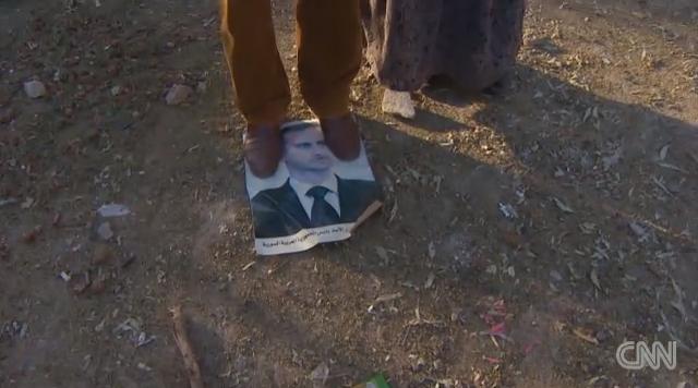 踏みつけられたシリアのアサド大統領の肖像