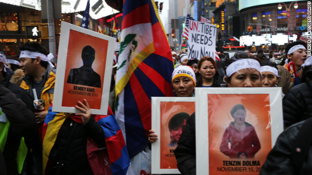 焼身自殺したチベット族のポスターを掲げて抗議する人々＝２０１２年１２月、米ニューヨーク