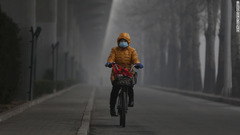 マスクをして自転車に乗る女性＝２３日