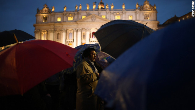 人々は新法王の発表を雨の中傘をさして待った