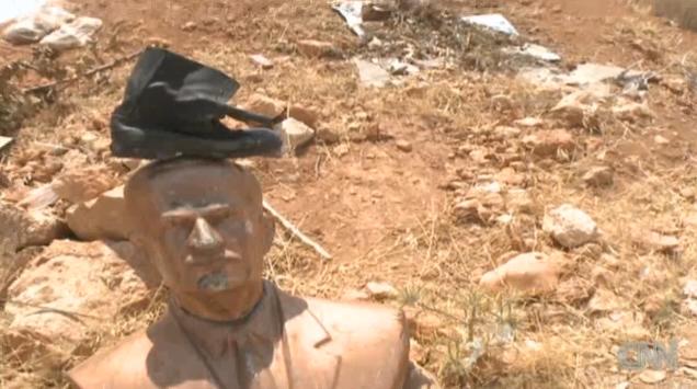 頭に靴を載せられたアサド大統領の父親の像。政権を見限る軍幹部も目立ち始めている