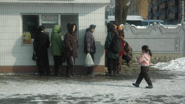 平壌市内の店が開くのを待つ人々＝２０１０年