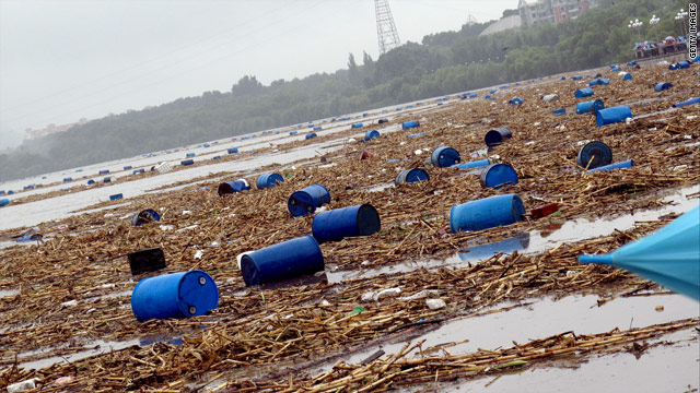 洪水後の川に浮かぶ化学薬品の容器