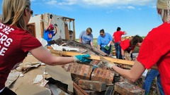 破壊された家の片付けを手伝う学校の教師