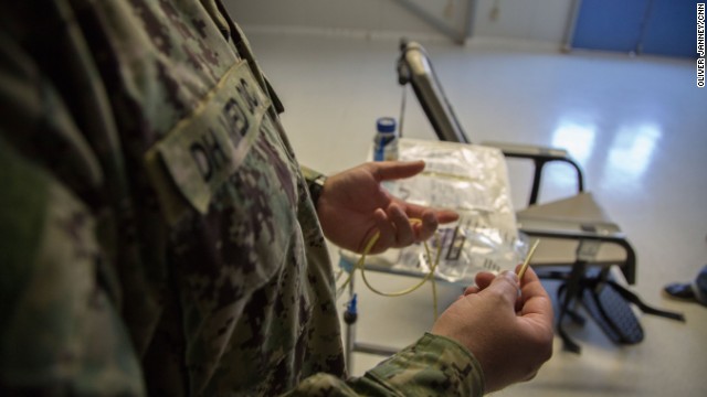 強制摂取に使われるチューブを手にする軍医