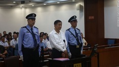警官２人に挟まれ被告人席に立つ薄熙来被告（中央）＝中級人民法院提供