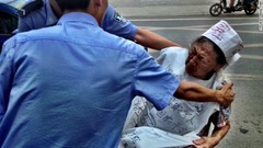 裁判所前では中国の司法制度に抗議する高齢者が現れ、警察が拘束した