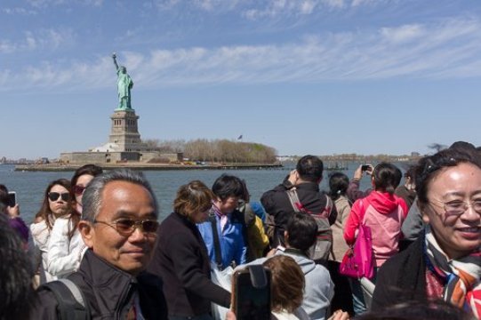 自由の女神などを見物する中国人観光客