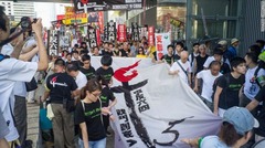 大きな横断幕を広げて歩く人々