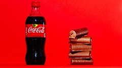 コカ・コーラの場合：６００ミリリットル入りのボトル１本に含まれる砂糖の量は６５グラム。これは１口サイズのチョコロールケーキ５個分に相当する(C)Mark Hill/CNN