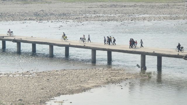 橋を渡る住民。昨年の洪水でいくつかの橋が流されたという