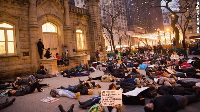 抗議のために地面に横たわる「ダイ・イン」を行う人々