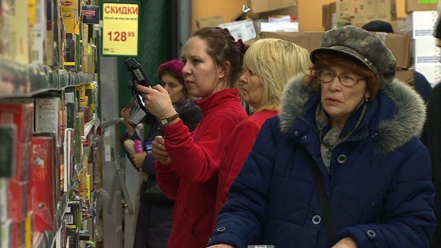商品を見つめるロシアの買い物客。原油価格の下落や欧米からの経済制裁による経済状況の悪化を受け、ロシア国債の格付けが引き下げられた