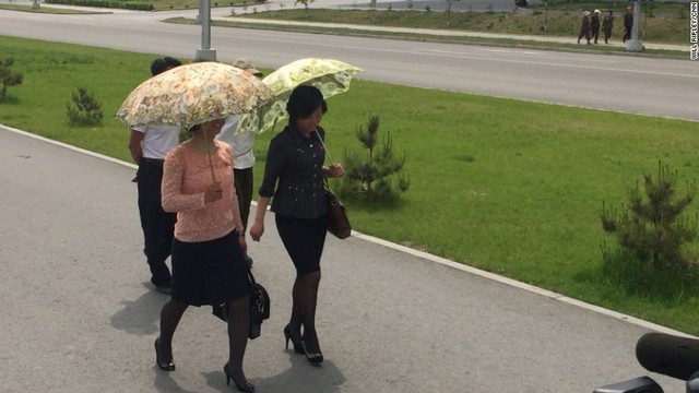日傘をさすなど、日曜日に着飾った平壌の女性
